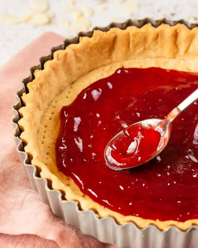 Spread the jam in an even layer in the baked pastry shell...