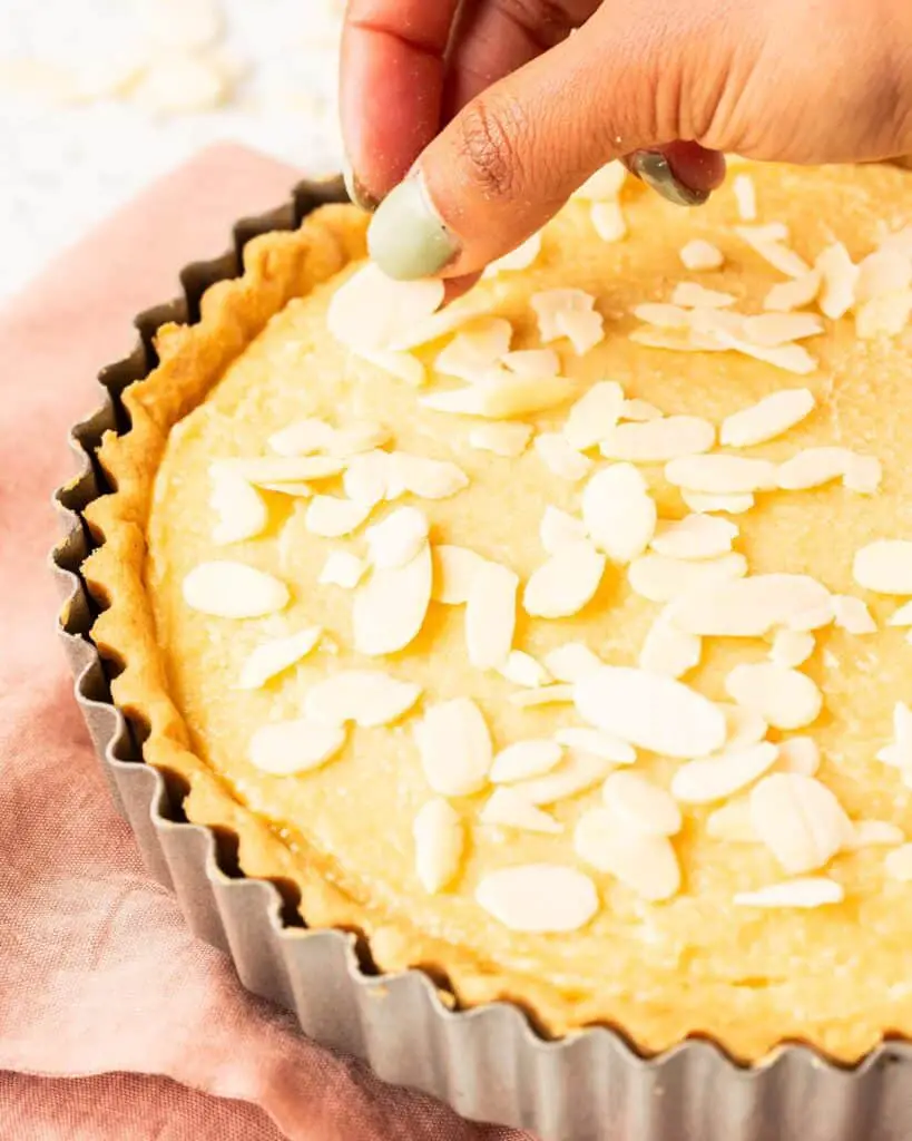 Sprinkling on the flaked almonds before baking. Recipe by movers and bakers