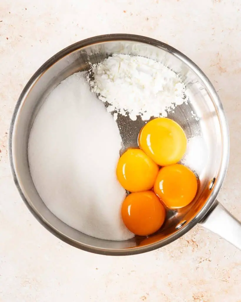 Combining the yolks, sugar, cornflour and salt in a saucepan...