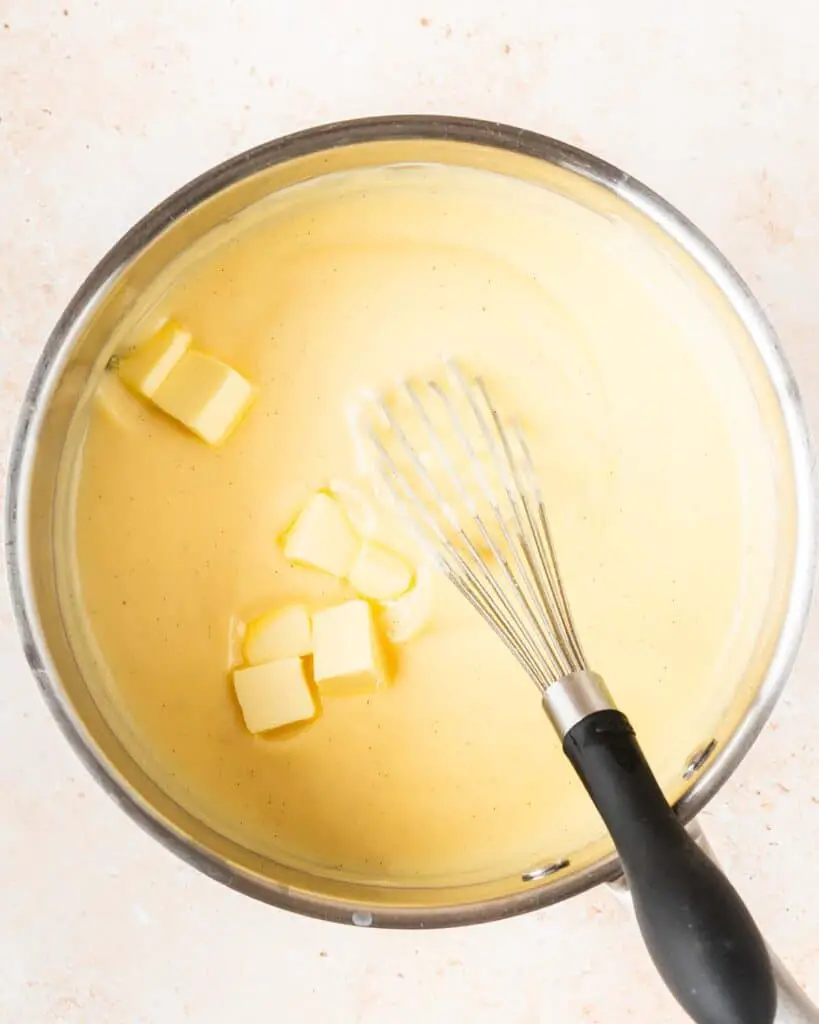 Whisking in the butter after cooking before leaving to cool. Recipe by movers and bakers
