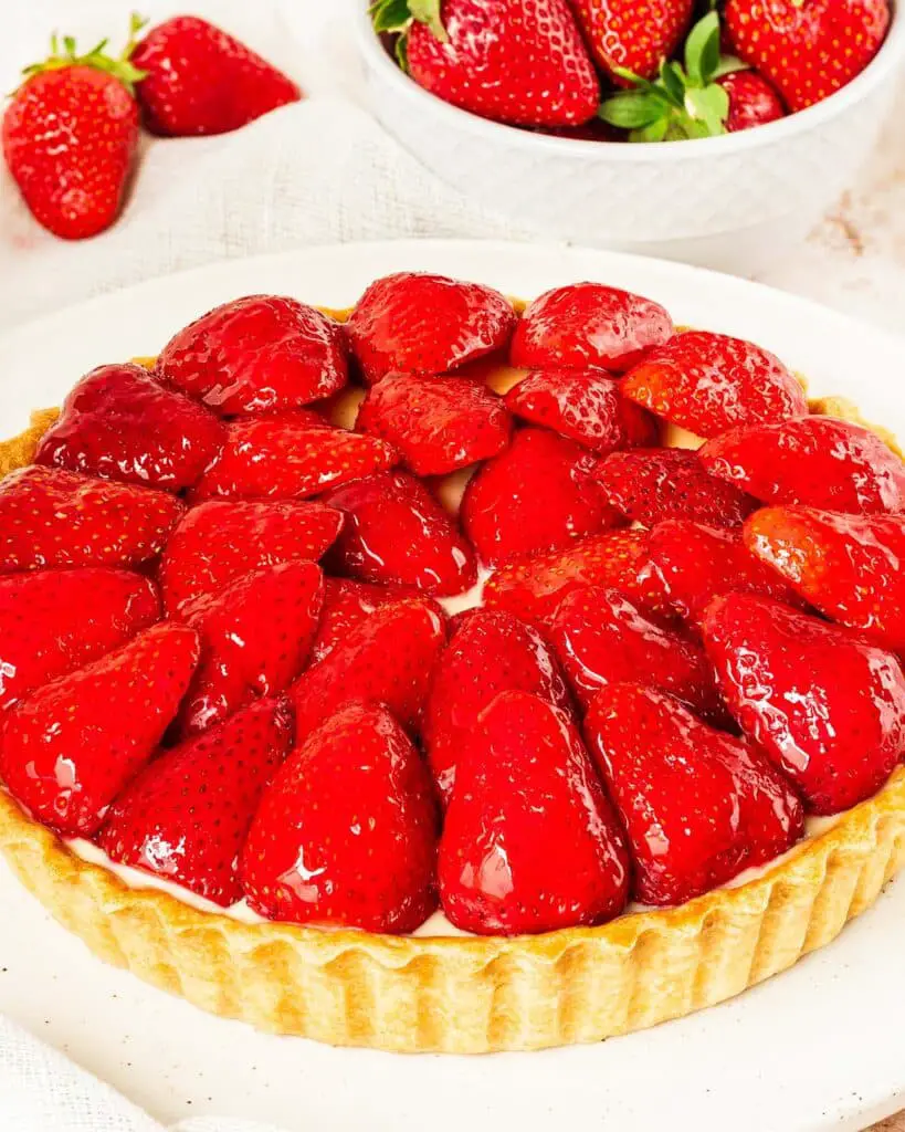 My strawberry tart recipe is hugely inspired by the glorious French strawberry tart we enjoy during out holidays! Buttery shortcrust pastry, smooth creme patisserie and beautifully glazed fresh strawberries make this a summertime treat! Recipe by movers and bakers