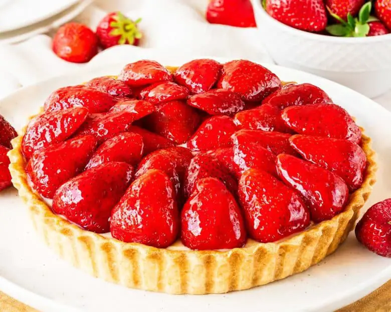 My strawberry tart recipe is hugely inspired by the glorious French strawberry tart we enjoy during out holidays! Buttery shortcrust pastry, smooth creme patisserie and beautifully glazed fresh strawberries make this a summertime treat! Recipe by movers and bakers