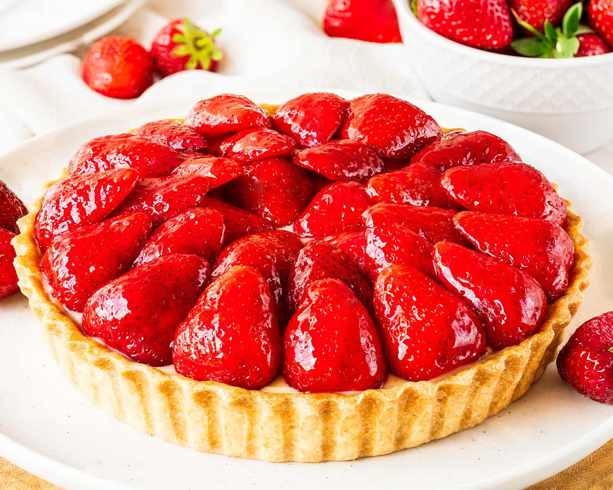 My strawberry tart recipe is hugely inspired by the glorious French strawberry tart we enjoy during out holidays! Buttery shortcrust pastry, smooth creme patisserie and beautifully glazed fresh strawberries make this a summertime treat! Recipe by movers and bakers