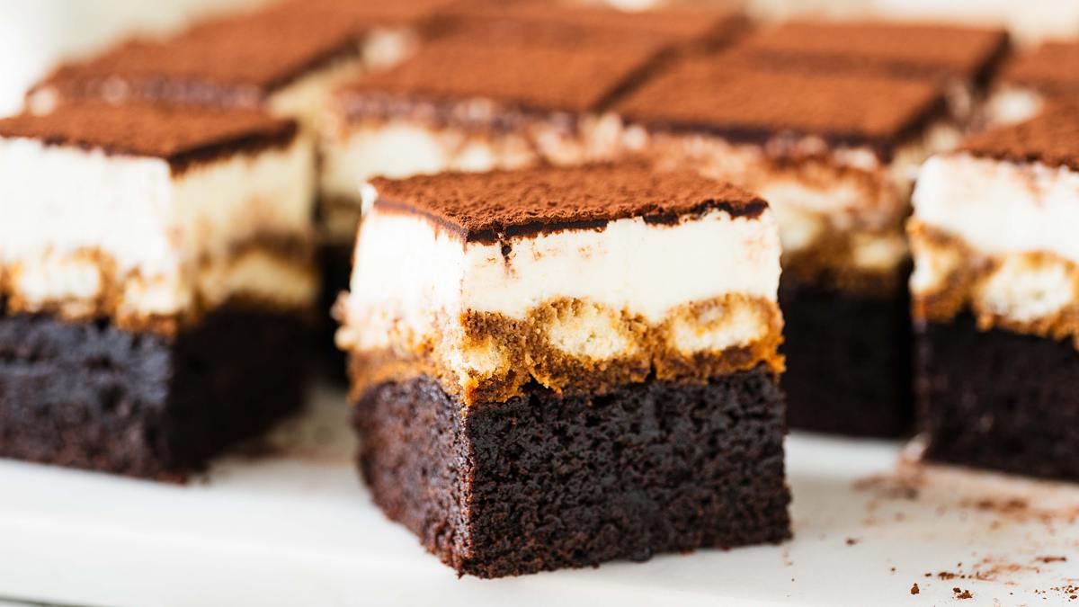 Tiramisu brownies. Putting together two of my all time favourite desserts to make one epic mash-up! Fudgy brownie, coffee laced sponge fingers and silky mascarpone cream all topped with a generous dusting of cocoa. Utterly heavenly! Recipe by movers and bakers