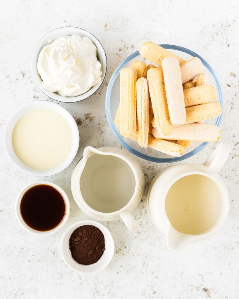 Ingredients for the topping: water, espresso powder, coffee liqueur (optional), sponge fingers, double (heavy) cream, mascarpone cheese, condensed milk and cocoa (not pictured). Recipe by movers and bakers