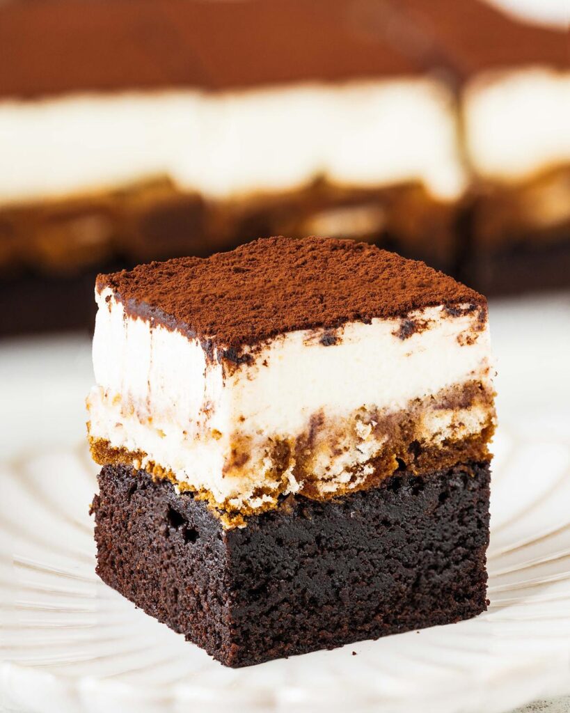 Tiramisu brownies. Putting together two of my all time favourite desserts to make one epic mash-up! Fudgy brownie, coffee laced sponge fingers and silky mascarpone cream all topped with a generous dusting of cocoa. Utterly heavenly! Recipe by movers and bakers