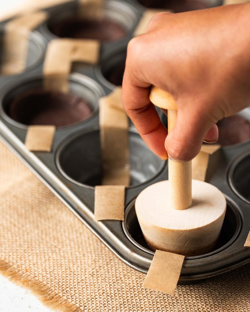 Pressing the cookie dough into the wells so they come up the sides...