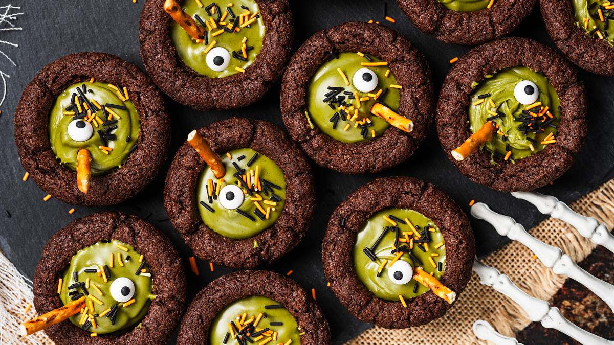 My witches’ cauldron cookie cups are chewy chocolate cookies filled with a delicious “potion” and sprinkles. A fun Halloween for everyone! Recipe by movers and bakers