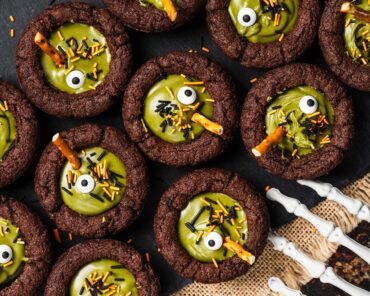 My witches’ cauldron cookie cups are chewy chocolate cookies filled with a delicious “potion” and sprinkles. A fun Halloween for everyone! Recipe by movers and bakers
