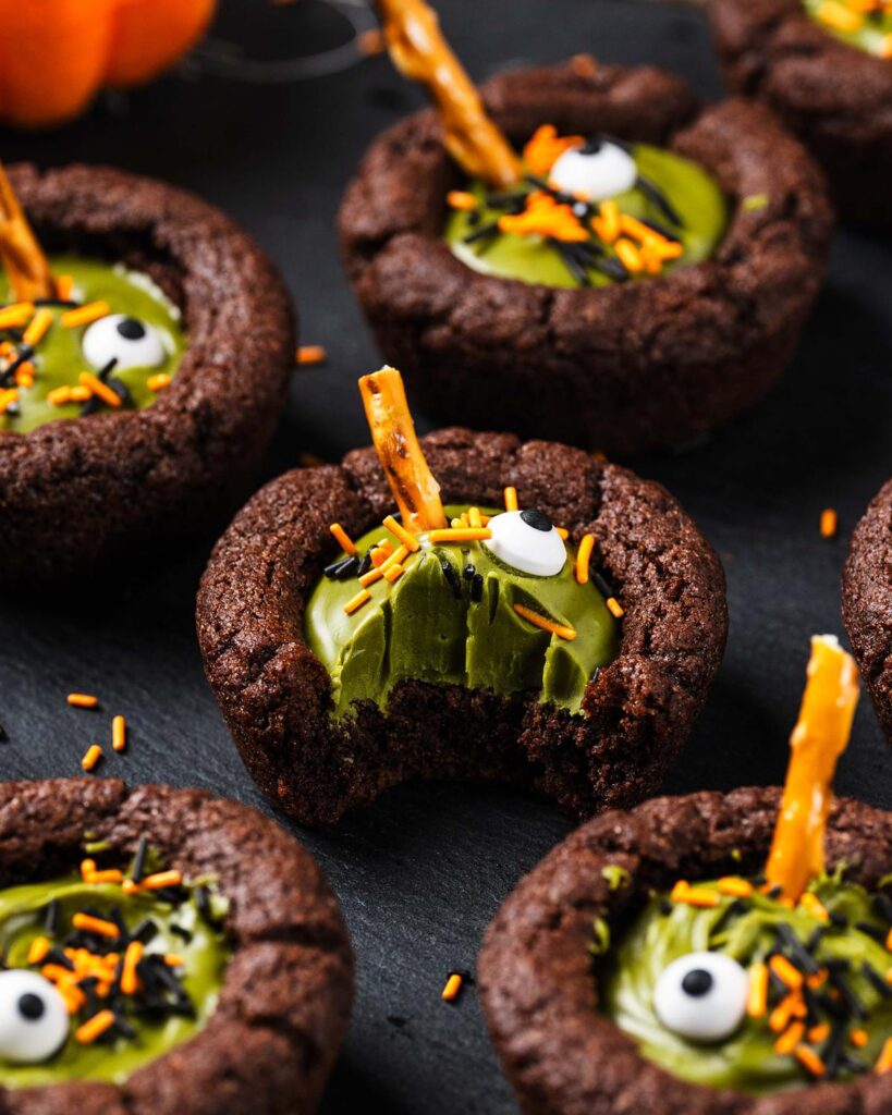 My witches’ cauldron cookie cups are chewy chocolate cookies filled with a delicious “potion” and sprinkles. A fun Halloween for everyone! Recipe by movers and bakers