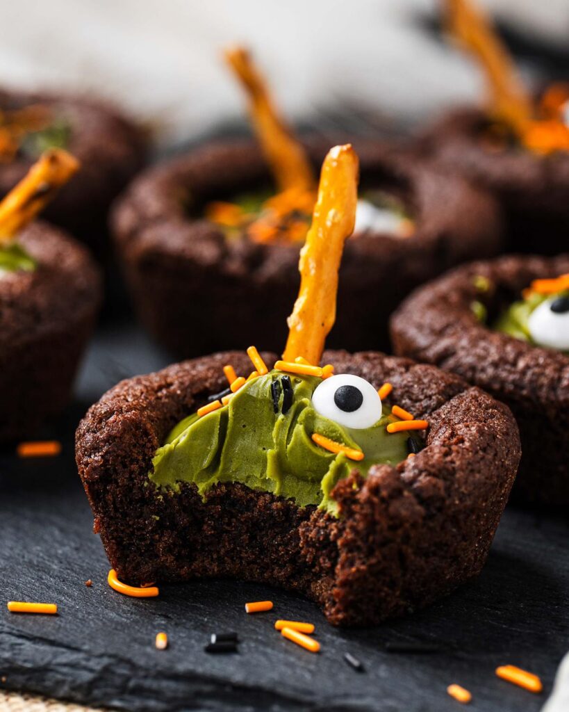 My witches’ cauldron cookie cups are chewy chocolate cookies filled with a delicious “potion” and sprinkles. A fun Halloween for everyone! Recipe by movers and bakers