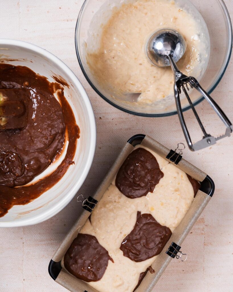 Layering the two mixtures in the loaf tin before baking. Recipe by movers and bakers