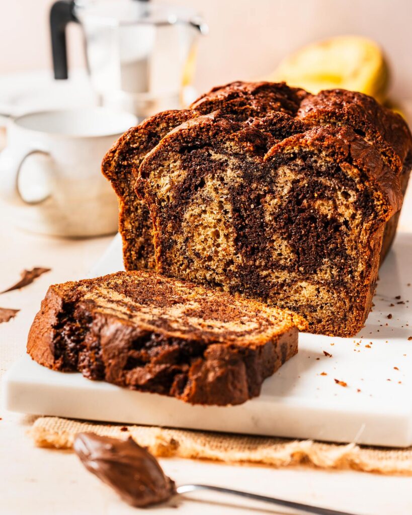 Elevate the classic banana bread with Nutella delectable twist on a classic! Nutella banana bread is the perfect homely bake for any time! Recipe by movers and bakers