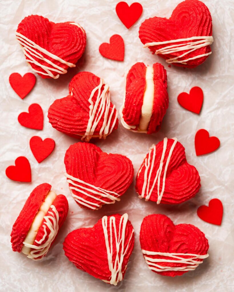 My Valentine's Viennese hearts are buttery, rich and utterly irresistible! Vibrant red piped shortbread biscuits filled with an airy whipped white chocolate ganache make these beauties perfect for Valentine's, Galentine's or any time! Recipe by movers and bakers