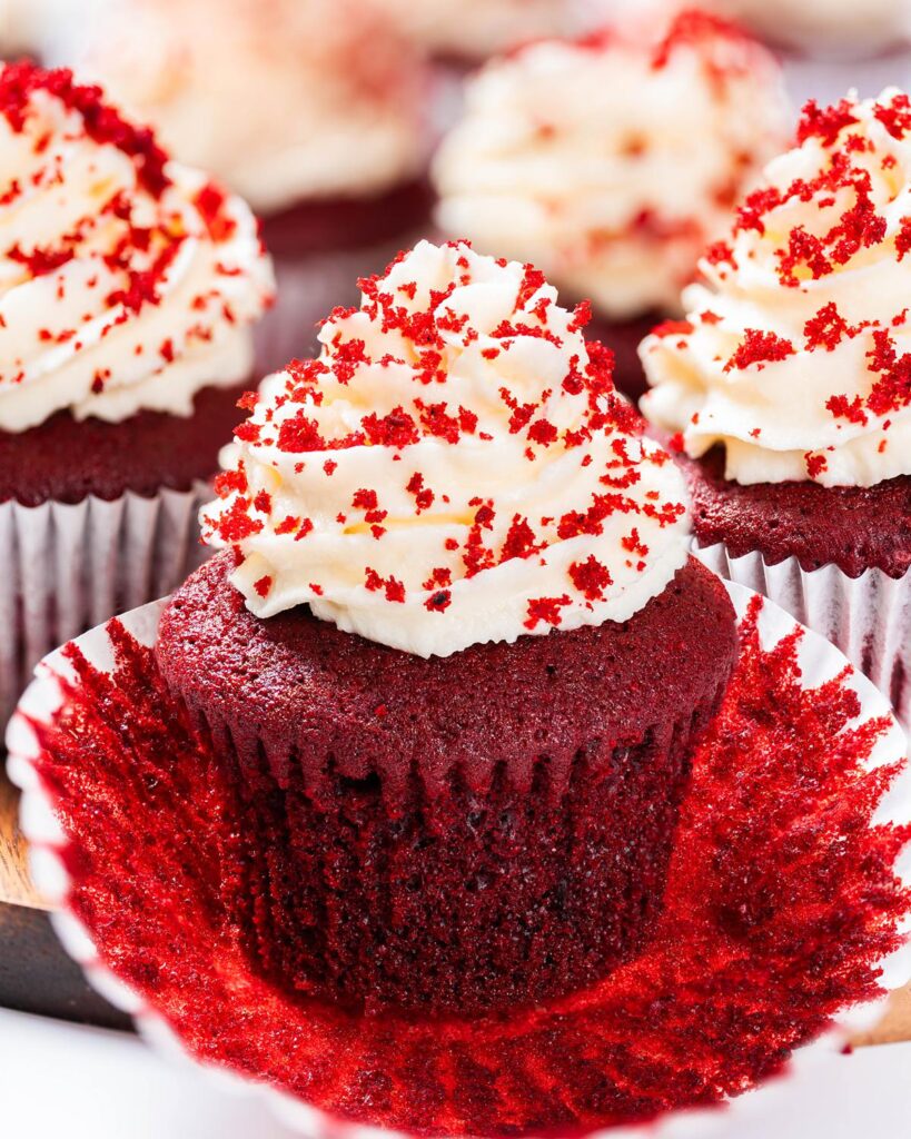 Vanilla and cocoa light velvety cupcakes topped with a glorious swirl of cream cheese frosting, these red velvet cupcakes are absolutely irresistibly divine! Recipe by movers and bakers