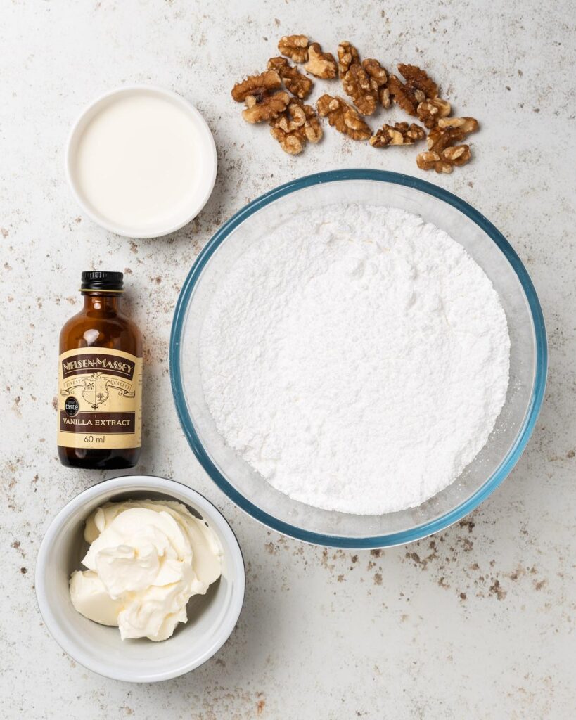 Ingredients for the glaze and decoration: cream cheese, icing (powdered) sugar, milk, vanilla and walnuts. Recipe by movers and bakers
