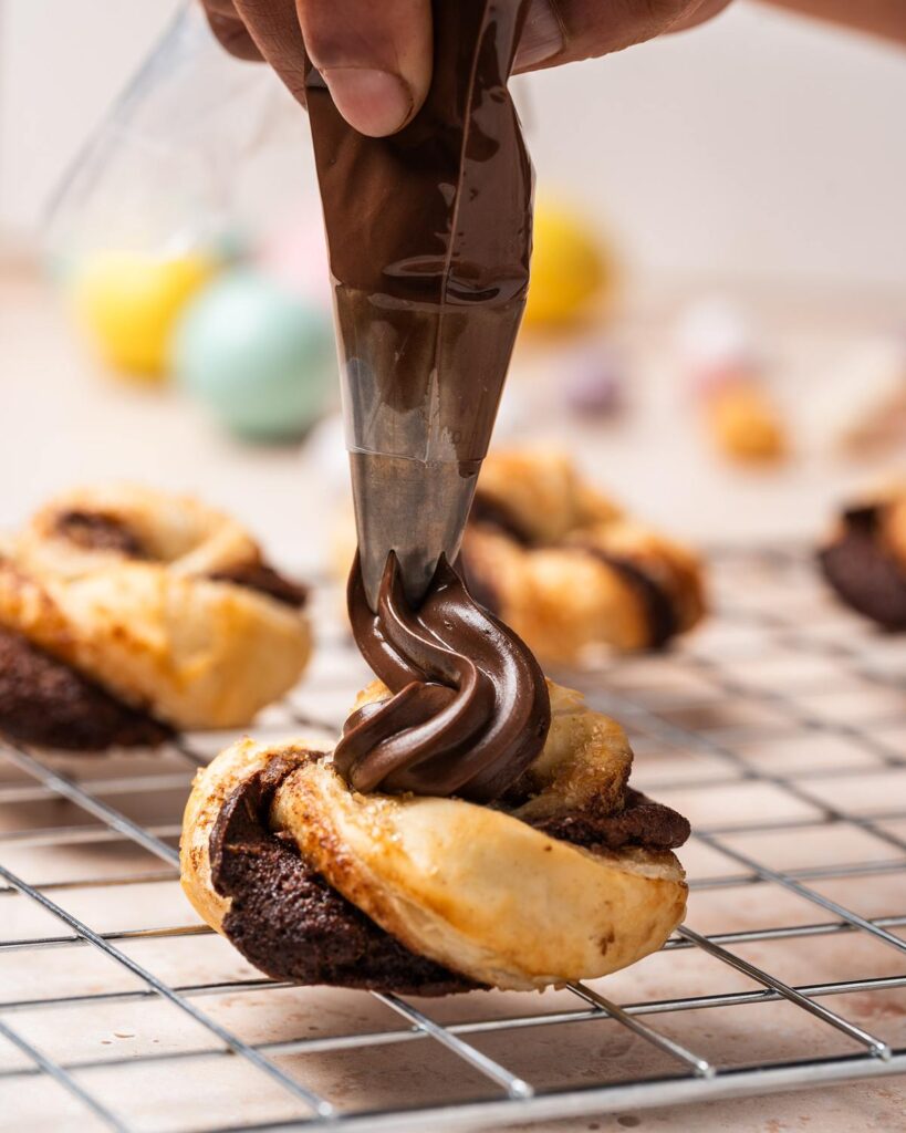 Pipe or spoon extra Nutella over the tops of the cooled nests...