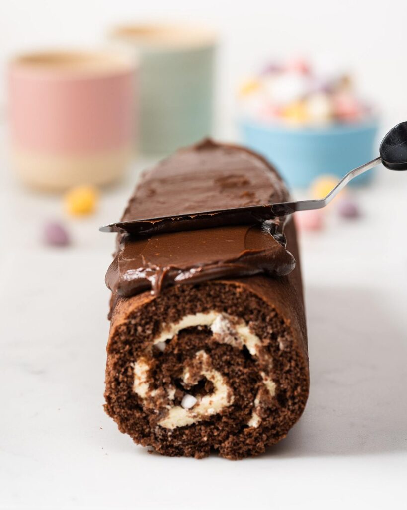 Spreading the ganache over the mini egg swiss roll...