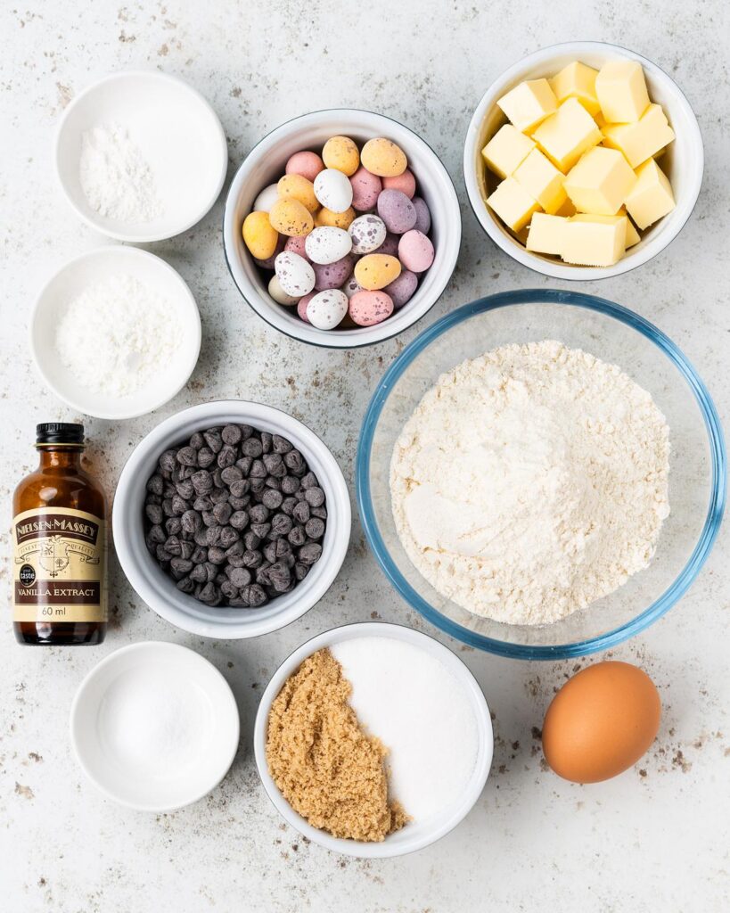 Ingredients required: unsalted butter, caster sugar, brown sugar, plain (all purpose) flour, bicarbonate of soda (baking soda), baking powder, salt, cornflour, chocolate chips, mini eggs and an egg. Recipe by movers and bakers