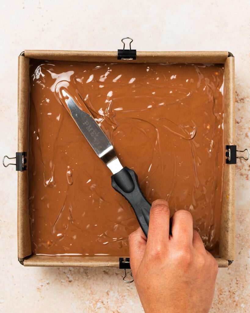 Spread the chocolate on top and tip or spread into an even layer, then leave to set before cutting into squares. Recipe by movers and bakers