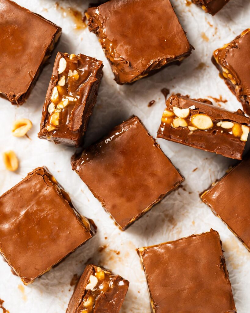 If you're a fan of a Snickers chocolate bar, you are going to LOVE this incredible snickers fudge. Chocolate fudge, caramel peanuts and a layer of milk chocolate topping makes these the ultimate treat everyone will love! Recipe by movers and bakers