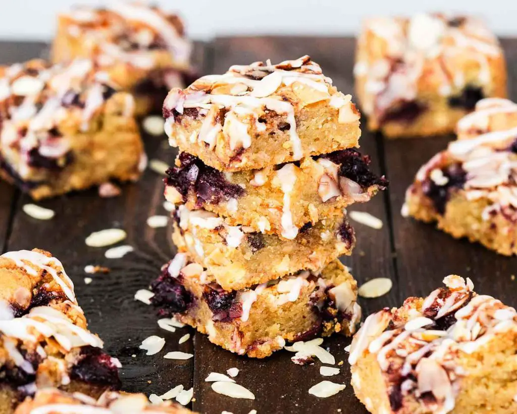 A stack of cherry bakewell blondies sprinkled with flaked almonds