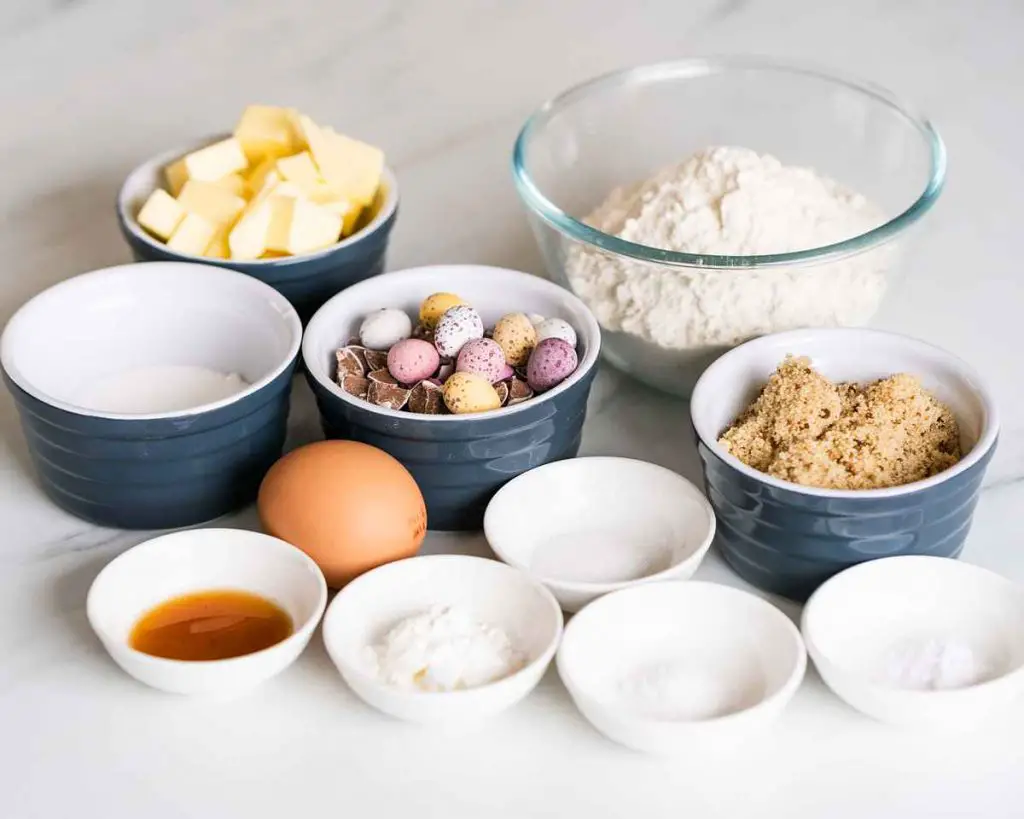 Ingredients for the cookies: butter, brown sugar, caster sugar, vanilla, plain flour, baking powder, bicarbonate of soda, salt, cornflour, chocolate chips, mini eggs and an egg. Recipe by movers and bakers