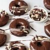 Soft, light and moist chocolate doughnuts with a delicious chocolate fudge glaze, white chocolate drizzle and chocolate curls to finish