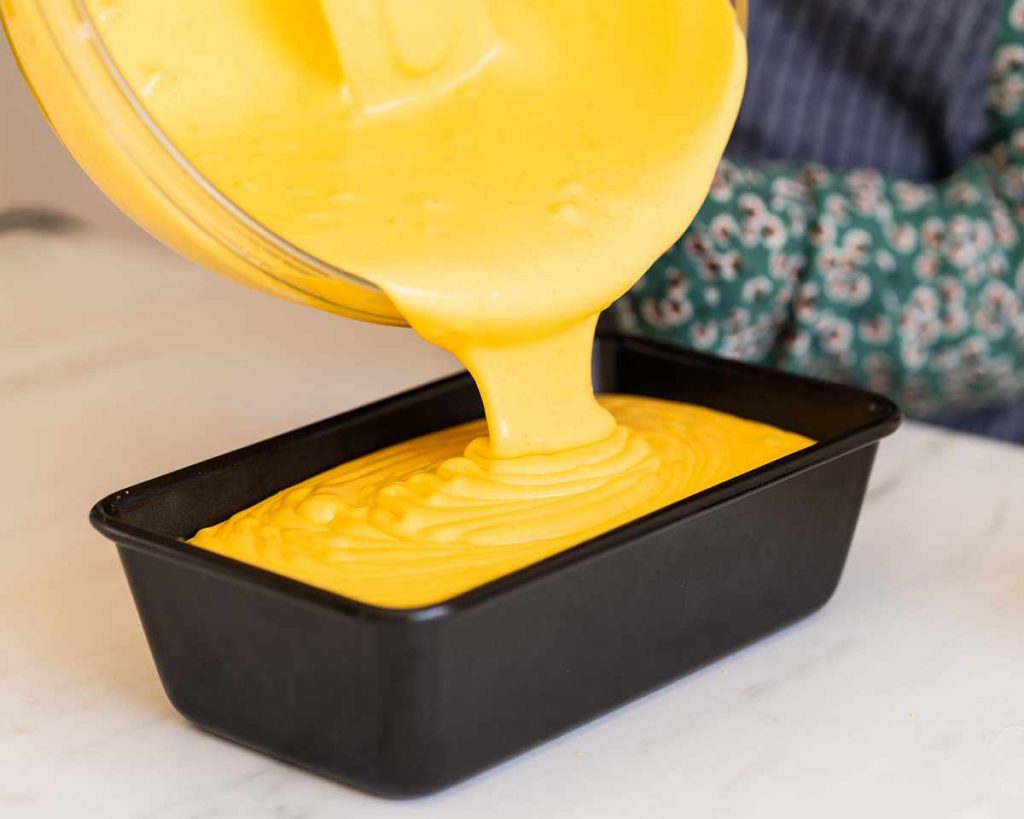 Pouring the ice cream into the tin before freezing. Isn't that mango colour just glorious? Recipe by movers and bakers