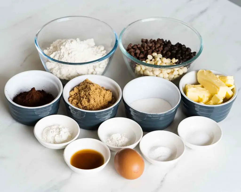 Ingredients needed for triple chocolate cookies: unsalted butter, brown sugar, caster sugar, vanilla, plain (all purpose) flour, cocoa powder, cornflour (cornstarch), baking powder, bicarbonate of soda (baking soda), salt, chocolate chips (milk, dark and white) and a large egg. Recipe by movers and bakers