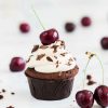 My Black Forest cupcakes are light but deeply chocolatey cupcakes, laced with Kirsch and filled with delicious black cherry compote, then topped with a buttercream swirl, grated chocolate and a cherry on top. Recipe by movers and bakers