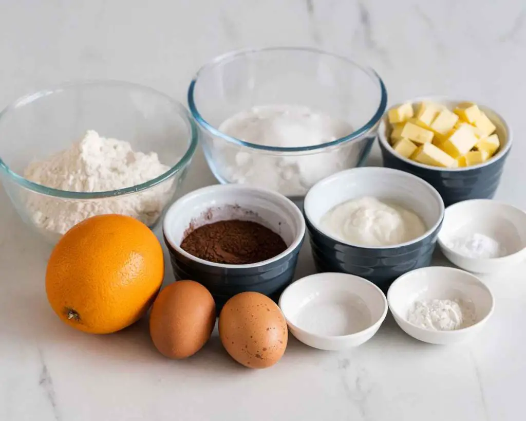 Ingredients needed for this loaf: caster sugar, orange, unsalted butter, flour, cocoa powder, baking powder, bicarbonate of soda (baking soda), salt, yogurt, eggs and marmalade. Recipe by movers & bakers