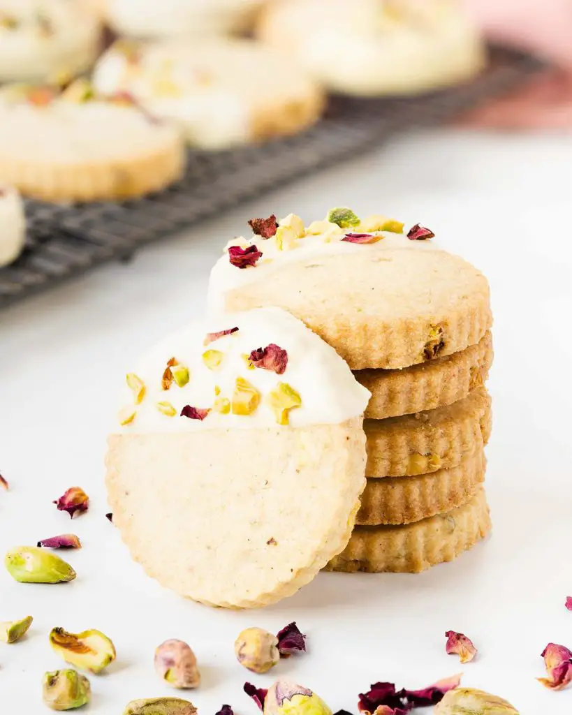 Stack of pistachio shortbread cookies with pistachio and rose petals