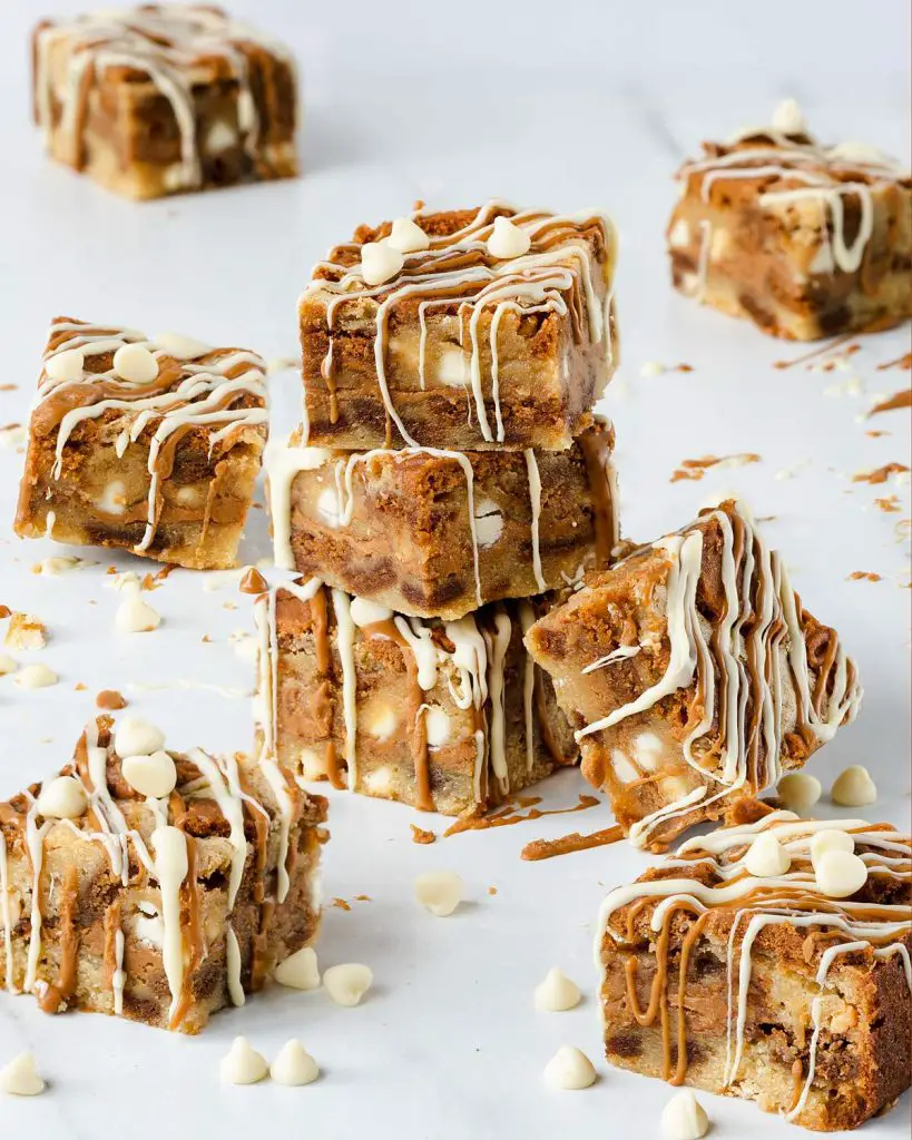 Ultra indulgent Biscoff blondies crammed full of Biscoff biscuits and spread and finished with a drizzle of Biscoff spread and white chocolate | Recipe from moversandbakers.co.uk
