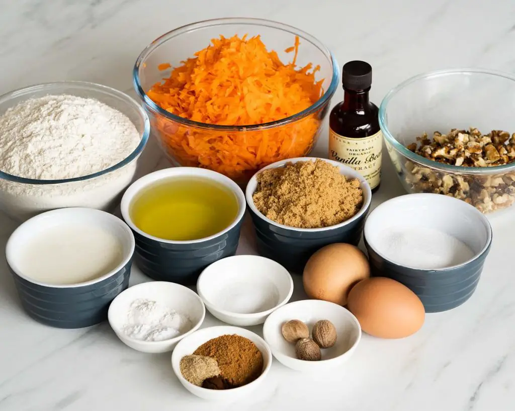 Ingredients needed to make this tray bake cake: vegetable oil, caster sugar, brown sugar, vanilla, eggs, buttermilk, carrots, plain flour, baking powder, bicarbonate of soda, salt, cinnamon, nutmeg, cloves, cardamom and walnuts. Recipe by movers and bakers