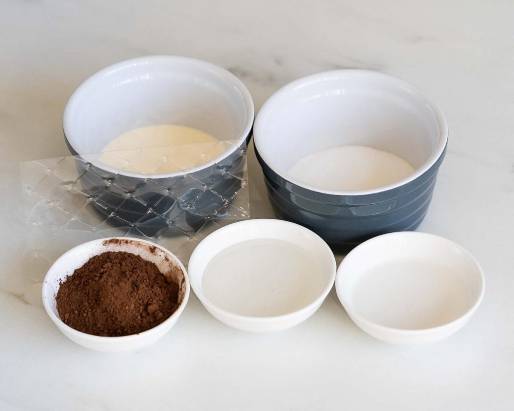 ingredients for the cocoa glaze: gelatine leaf, double cream, water, caster sugar, glucose syrup and cocoa powder. Recipe by movers and bakers