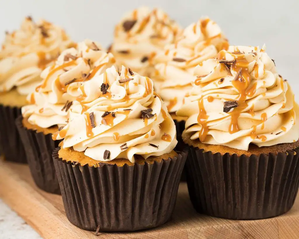 Banoffee cupcakes. Beautiful banoffee cupcakes with a biscuit base, hidden caramel centre, caramel buttercream and chocolate shavings. Perfect for all banana and caramel lovers! Recipe by movers and bakers