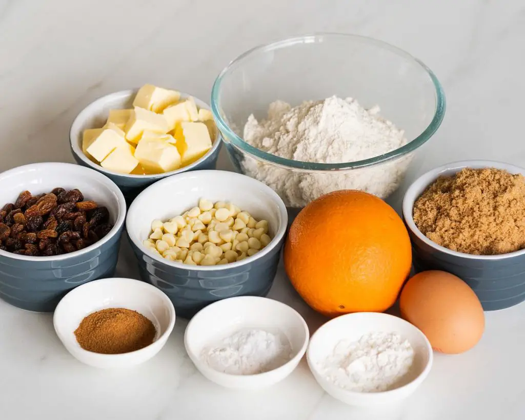 Ingredients needed: unsalted butter, brown sugar, egg, plain (all purpose) flour, baking powder, bicarbonate of soda (baking soda), cinnamon, cornflour (cornstarch), sultanas and white chocolate. Recipe by movers and bakers