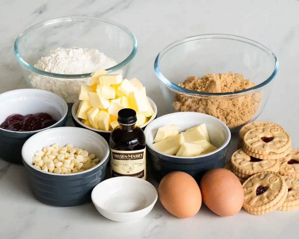 Ingredients needed for this bake: unsalted butter, brown sugar, white chocolate, vanilla, eggs, plain (all purpose) flour, salt, (raspberry) jam, jammie dodger biscuits. Recipe by movers and bakers