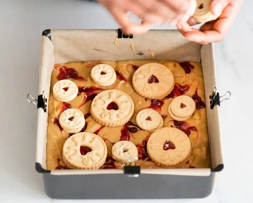 Finally, top your blondie with some whole jammie dodger biscuits. I like to use a mixture of full sized and mini jammie dodgers as I like seeing the jam swirls in between the biscuits. Recipe by movers and bakers