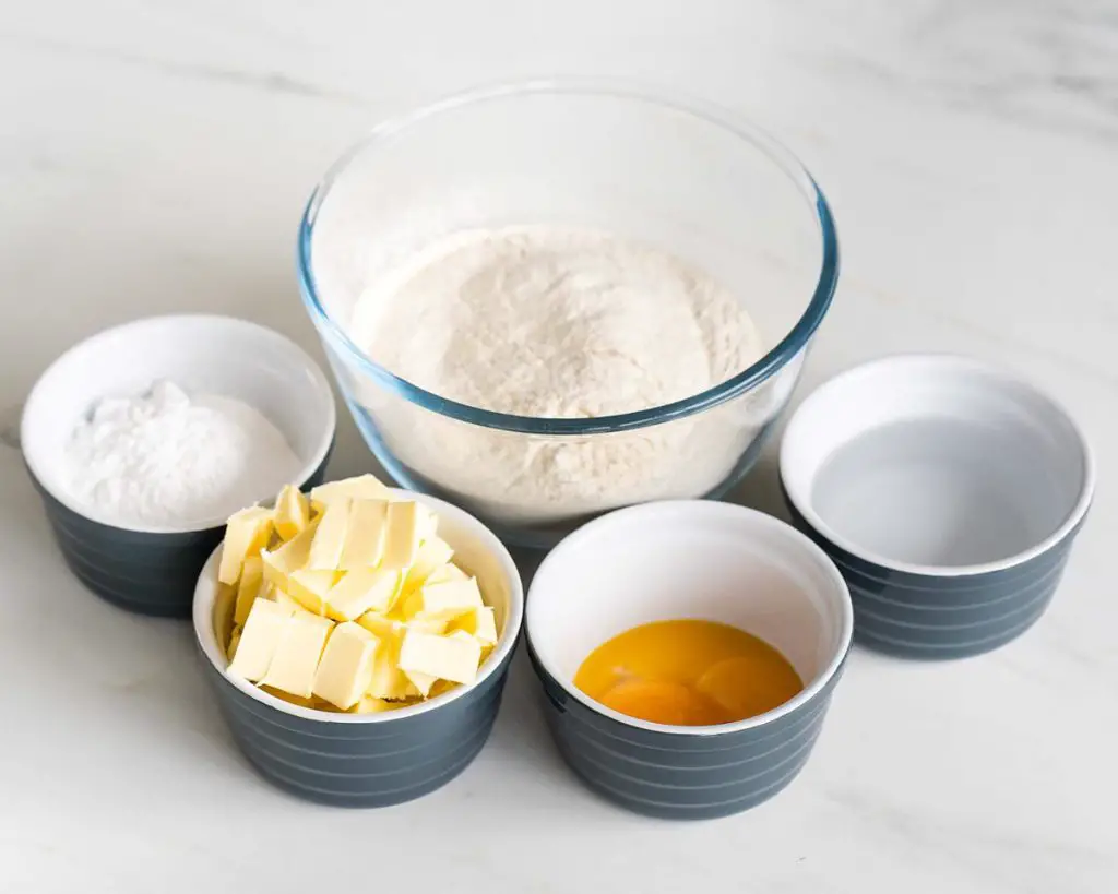 ingredients for the pastry: plain (all purpose) flour, icing sugar, butter, egg yolks and ice cold water. Recipe by movers and bakers