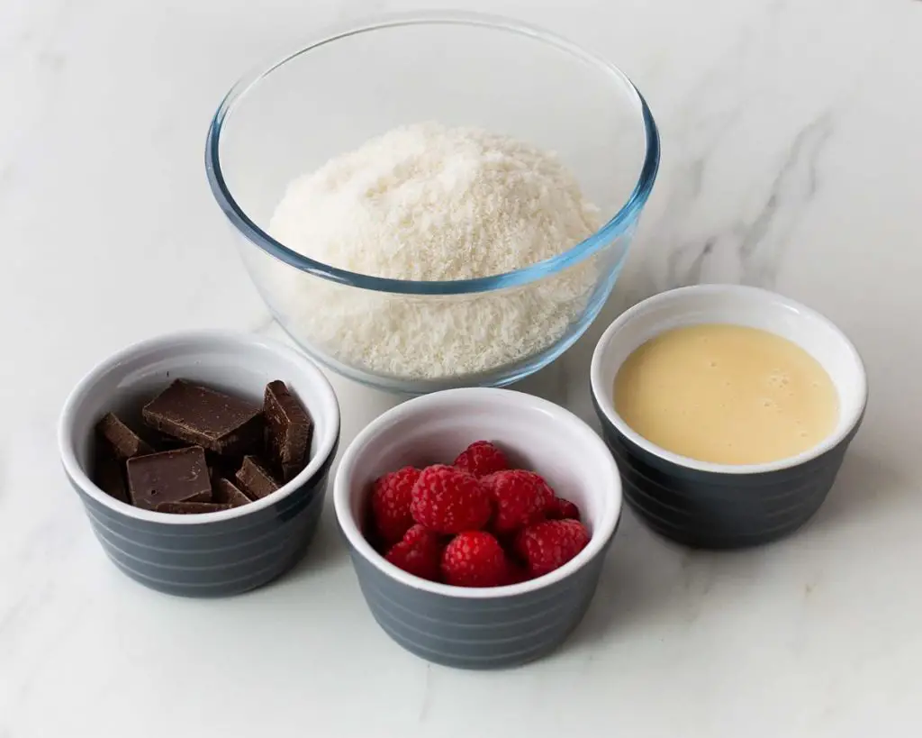 Ingredients needed: raspberries, dessicated coconut, condensed milk and dark chocolate. Recipe by movers and bakers