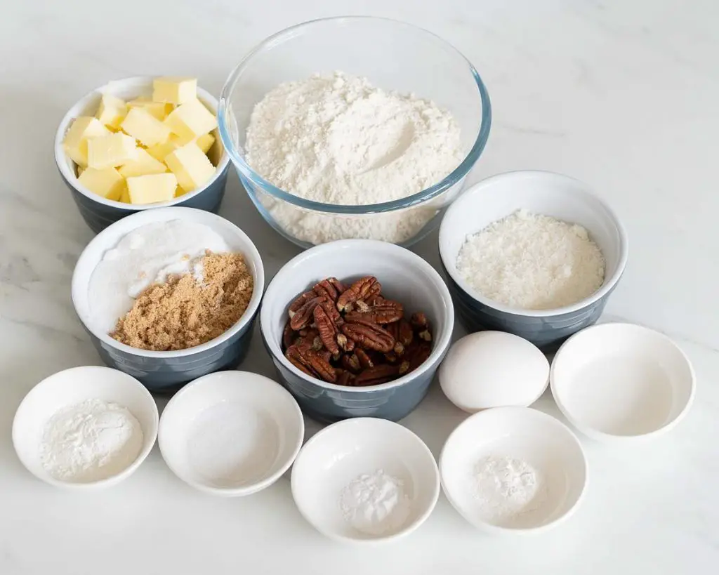 Ingredients needed: unsalted butter, brown sugar, caster sugar, coconut extract, plain (all purpose) flour, cornflour (cornstarch), baking powder, bicarbonate of soda (baking soda), salt, pecans, desiccated coconut and an egg. Recipe by movers and bakers