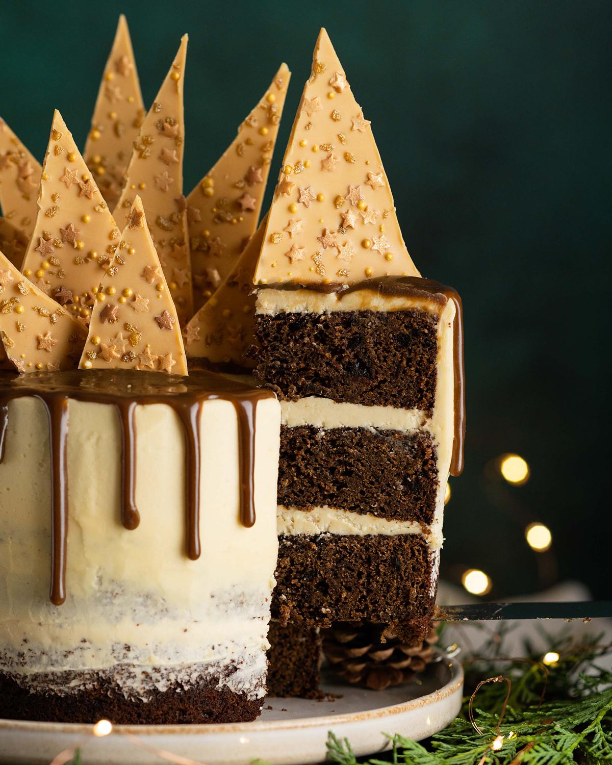 Sticky toffee pudding cake. Three layers of rich date sponge cake, sandwiched together with caramelised white chocolate buttercream, toffee drip and caramelised white chocolate shard topping. Recipe by movers and bakers
