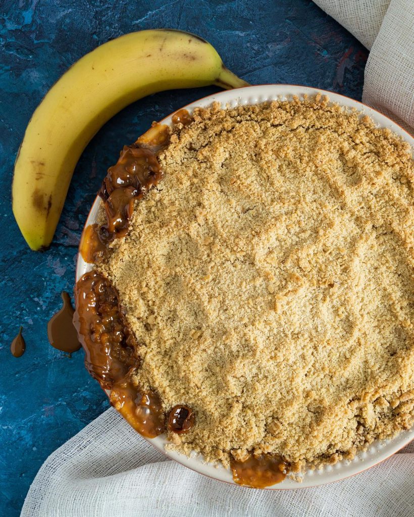Banoffee crumble. Soft bananas layered generously with a thick caramel and topped with a lightly spiced golden crumble topping. Perfect autumnal baking! Recipe by movers and bakers