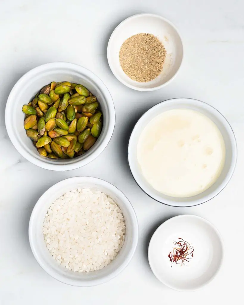 Ingredients needed: pudding rice, water, condensed milk, cardamom powder, saffron strands, pistachios and dried rose petals. Recipe by movers and bakers