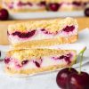 Cherry cheesecake bars. Delicious shortbread, creamy eggless baked cheesecake and rich cherry pie filling topped with more shortbread crumbs. This is one cheesecake no one can turn down! Recipe by movers and bakers